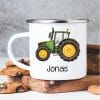 Auf dem Bild ist das Produkt: Campingbecher Emaille mit einem grünen Traktor Trecker personalisiert mit Wunschname Geschenk Junge zum Preis von €18.90 abgebildet.